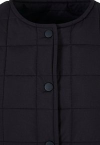 Veste matelassée noire avec un col rond, des boutons-pression sur le devant et une texture douce et lisse. Le design comprend des motifs carrés cousus.