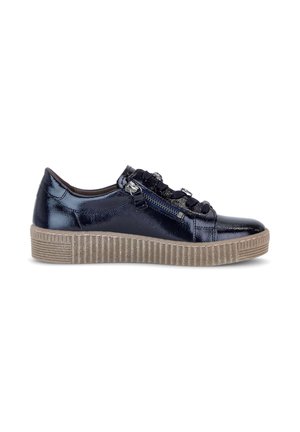 Lavskaftet skinnende marineblå sneaker med tyk beige riflede sål, sorte snørebånd og lynlås i siden på hvid baggrund.