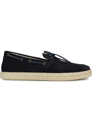 Marineblauwe suède espadrille met een ronde neus, gevlochten zijkanten en een geweven jute zool. Kenmerkt zich door minimale stiksels en tonale accenten.