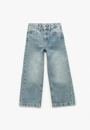 Lichtblauwe denim wijdvallende jeans met versierde studs op de voorkant. Voorzien van een knoop- en ritsluiting, vijf zakken en riemlussen.