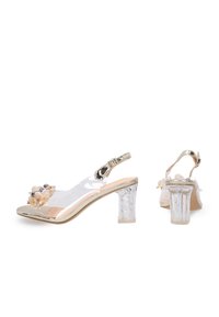 Klarsicht-Absatz-Slingback-Sandalen mit floralen Akzenten, metallischen Verzierungen und transparentem Obermaterial. Blockabsatz, der wie Kristall aussieht.