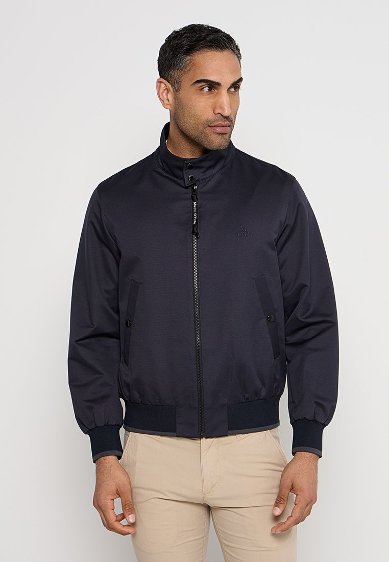 Marineblaues Bomberjacke aus glattem Stoff mit hohem Kragen, Frontreißverschluss, zwei seitlichen Taschen und elastischem Saum und Ärmelbündchen.