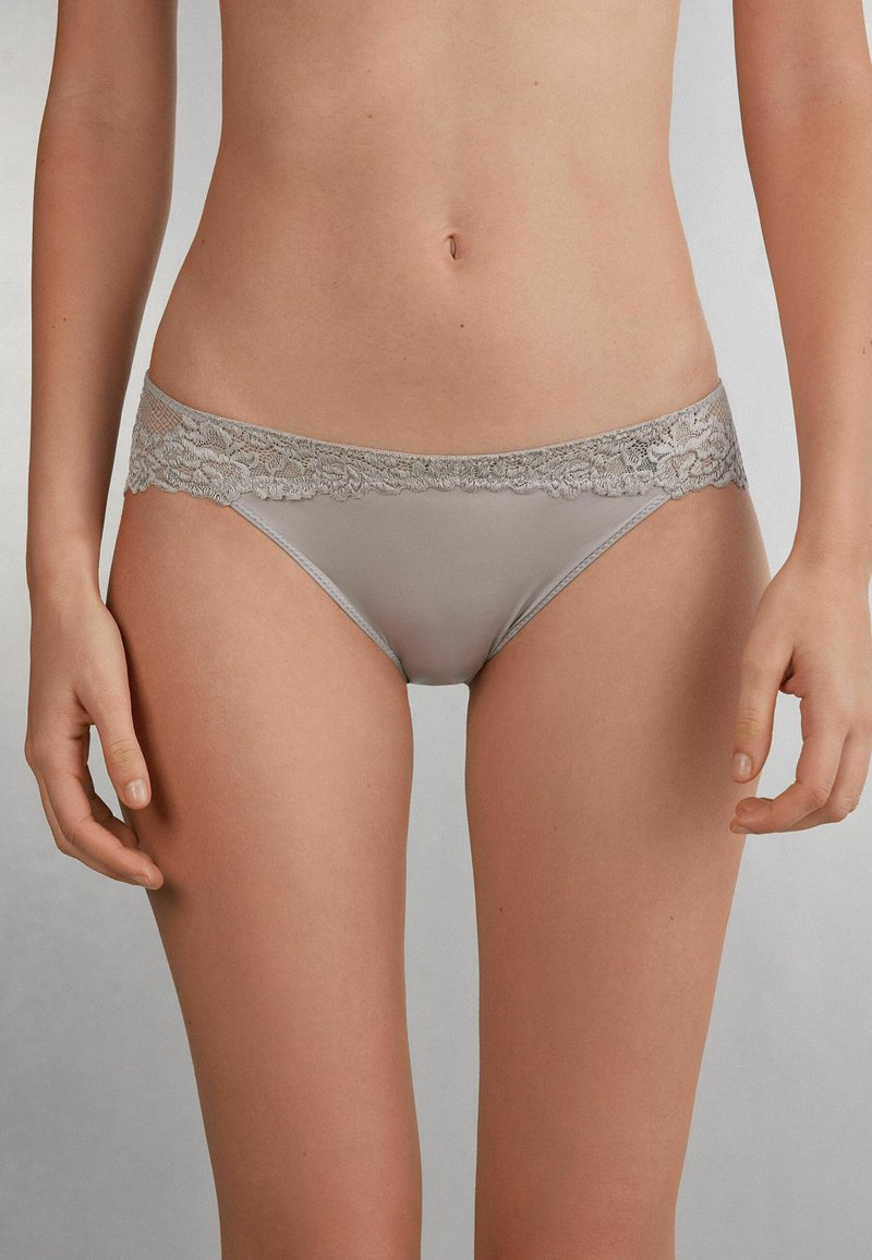Grijze briefs met kant bevatten een zachte, gladde stof met een delicate bloemenkant tailleband en een klassieke bikini snit voor een strakke pasvorm.