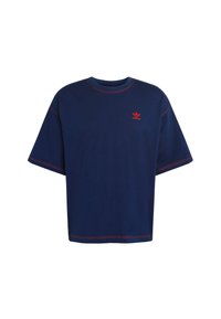 Navy modrá oversized tričko vyrobené z bavlny, se červeným prošitím a malým červeným logem na hrudi. Krátké rukávy a kulatý výstřih.