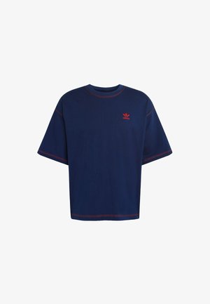 Navy blue oversized T-shirt made of cotton, featuring red stitching and a small red logo on the chest. Short sleeves and round neckline.