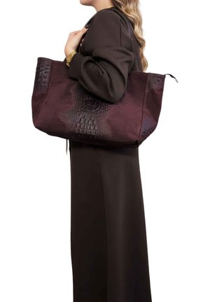 Grande borsa tote color bordeaux con motivo a coccodrillo testurizzato su un lato, realizzata in pelle con tessuto liscio sull'altro lato.