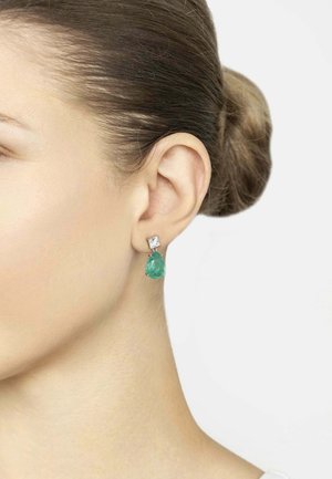 Emerald green teardrop earrings with a clear square accent, set in silver. The earrings have a polished finish and dangle slightly from the ear.