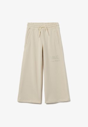 Pantalones de chándal beige de pierna ancha con cinturilla elástica, cordón, bolsillos laterales y el logo de strass "Everlast Dance Division" en el muslo derecho.