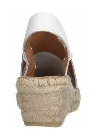 Sandale à talon compensé en cuir blanc avec un dessus texturé, arrière ouvert et talon enroulé de jute. Design de talon légèrement courbé, doublure intérieure lisse.