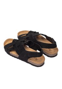 Sandales en daim noir avec un design à brides croisées, semelle en liège et semelle en caoutchouc texturé. Brides ajustables pour un maintien sécurisé.