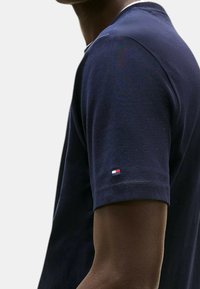 T-shirt a maniche corte di colore blu navy, realizzato in cotone, con scollatura rotonda e una piccola patch con logo sulla manica. Tessuto morbido.