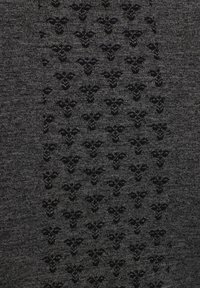 Strickstoff mit einem dunkelgrauen Grundton, versehen mit einem dezenten schwarzen Blumenmuster, das Textur und Tiefe erzeugt.