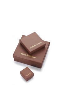 Drei geschlossene braune Geschenkboxen unterschiedlicher Größe, gestapelt und mit der Aufschrift "Rafaela Donata" in goldener Schrift auf einem weißen Hintergrund.