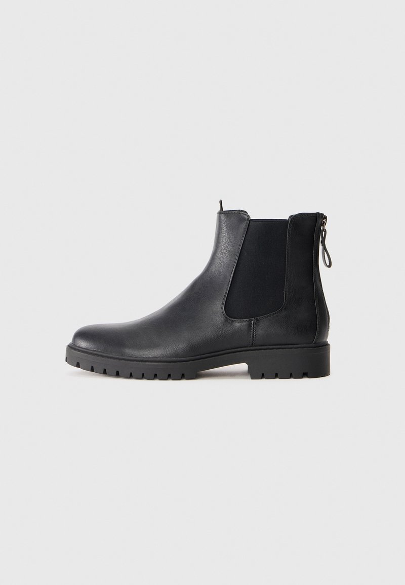 Botte Chelsea en cuir noir avec des panneaux élastiques latéraux, une fermeture éclair à l'arrière et une semelle en caoutchouc robuste, profil latéral sur fond blanc.