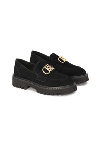 Mocassini in suede nero presentano una larga fascia con una fibbia in tono oro. La suola in gomma spessa offre grip, mentre la parte superiore ha una finitura liscia.