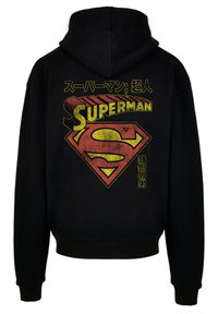Black hoodie featuring a large red and yellow Superman logo with Japanese text above and below the emblem. Soft fabric and elastic cuffs.