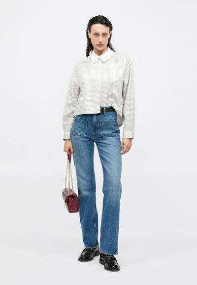 White and gray checkered cropped shirt with a collar, paired with light blue high-waisted jeans and a burgundy crossbody bag. Black shoes.