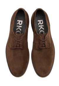 Une paire de chaussures de ville pour hommes en cuir suédé marron avec des semelles intérieures noires texturées et du texte de marque à l'intérieur, vue de dessus sur un fond blanc.