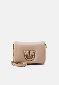 Borsa in pelle beige con tracolla in catena dorata, caratterizzata da una parte superiore arrotondata, una superficie liscia e un design con faccina sorridente decorato con due fiori.