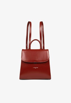 Sac à main en cuir rouge avec une forme structurée, une poignée supérieure et des sangles réglables. Il dispose d'une fermeture à rabat et d'un logo de marque en relief sur le devant.