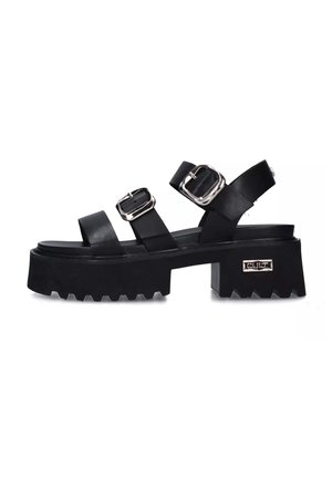 Zwarte platform sandalen met dubbele zilveren gespen, brede banden en een robuuste zool met een zigzagpatroon. Modern ontwerp met een chunky hak.