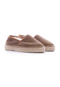 Espadrilles de tela marrón con suela de yute natural, que presentan una punta redondeada y paneles laterales elásticos para mayor comodidad. Textura suave en general.