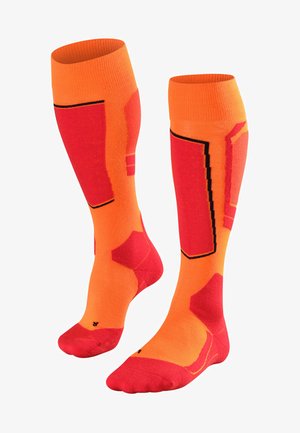 Calze fino al ginocchio di un vivace arancione con accenti rossi e motivi geometrici. Realizzate in materiale elastico, presentano sezioni rinforzate nella punta e nel tallone.