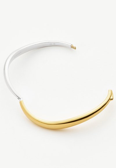Ανοιχτό βραχιόλι με κομψό σχέδιο, που διαθέτει γυαλιστερό χρυσό μπροστινό μέρος και ασημένιο πίσω μέρος πάνω σε λευκό φόντο.