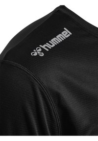 Svart sportskjorta med strukturerad tyg, korta ärmar och en framträdande grå "hummel"-logga på axeln.