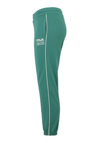 Gröna sweatpants med vita sidostreck, elastisk midja och muddar vid anklarna. Har en Fila-logotyp på vänster höftficka.
