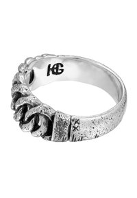 Silver ring med en vriden design, en texturerad band och en slät insida. Anmärkningsvärd gravyr och maskindetaljer.