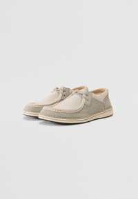 Gray and beige shoes made of suede and leather, with a rounded toe, stitching details, and a lace-up design. Soft interior lining.