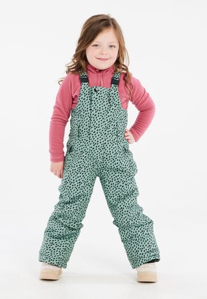 Tutina da neve verde a pois con spalline regolabili, tasche laterali e una comoda maglietta a maniche lunghe rosa sotto. Tessuto morbido.