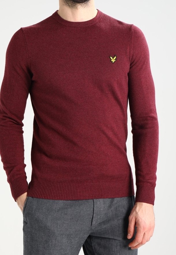 Bordeauxfarbener Pullover aus weichem Stoff mit langen Ärmeln, runder Halslinie, geripptem Saum und einem kleinen gelben Adler-Logo auf der linken Brust.
