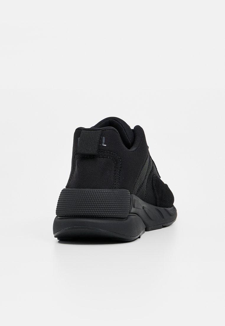 B baskets de sport noires avec un dessus en maille texturée et en daim, un col rembourré et une semelle en caoutchouc épaisse avec une adhérence à motif.