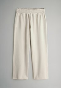 Krēmkrāsas bikses ar elastīgu jostasvietu, izgatavotas no mīksta auduma, ar taisnām kājsaitēm un bez papildu dekorācijas vai rakstiem.