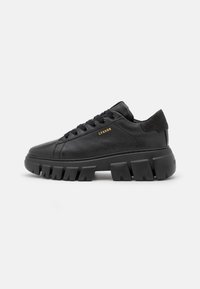 Czarne skórzane sneakersy z masywną gumową podeszwą i sznurówkami, z subtelnym logotypem na boku oraz gładką, teksturowaną cholewą.