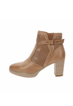 Bottine en cuir tan avec des panneaux perforés sur les côtés, un talon bloc et un détail de sangle réglable. Texture lisse avec un design épuré.