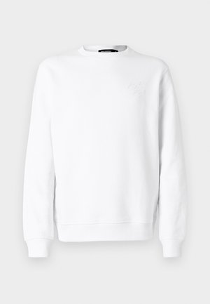 Hvit genser med rund hals, lange ermer, ribbestrikkede mansjetter og nederkant. Har subtile pregete detaljer på brystet. Glatt tekstur.