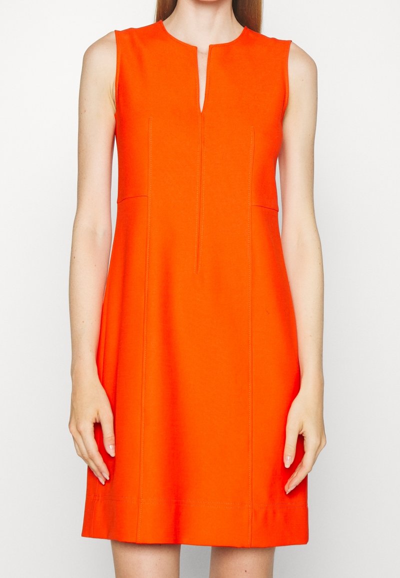 Robe sans manches orange à coupe droite, avec une fente à l'avant, des coutures ajustées et une texture de tissu lisse. Design minimaliste.