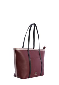 Bolso tote de cuero en color marrón y beige con asas negras, un bolsillo frontal y un pequeño detalle de logo metálico en la parte inferior frontal.