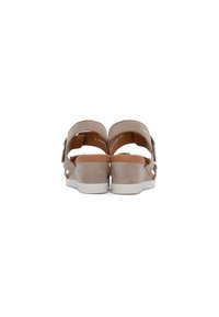 Beige Wildledersandalen mit Keilabsatz, zwei verstellbaren Knöchelriemen, einer weißen Gummisohle und einem angenehm strukturierten Fußbett. Rückansicht zeigt die Riemendetails.