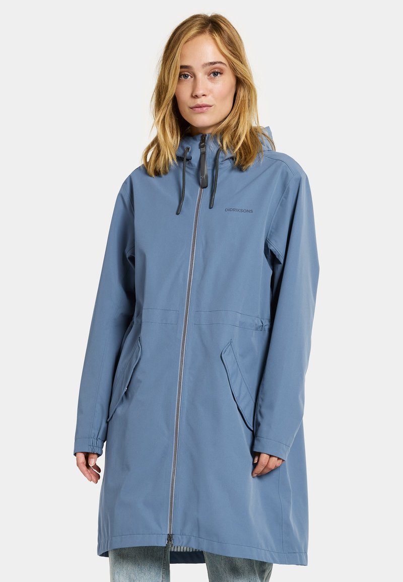 Himmelblau, wasserdichte knielange Jacke mit Reißverschluss vorne, verstellbare Kapuze und zwei seitlichen Taschen. Verfügt über elastische Bündchen und Branding.