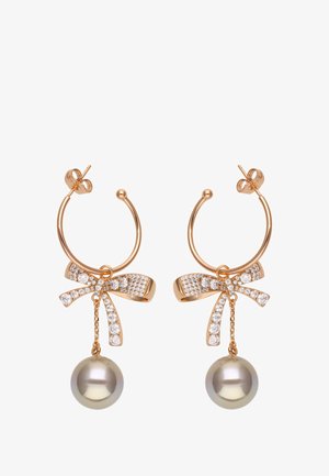 Orecchini a cerchio dorati con un design a fiocco, impreziositi da strass trasparenti e una perla grigia pendente. Finitura metallica liscia e accenti lucidi.