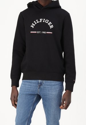 Black hoodie made of cotton blend, featuring a front logo in white text, with red and blue accents. Finished with a kangaroo pocket.