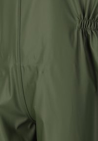 Olijfgroene, waterdichte stof met een gladde textuur; heeft elastische rimpelingen aan de achterkant en een naad in het midden.