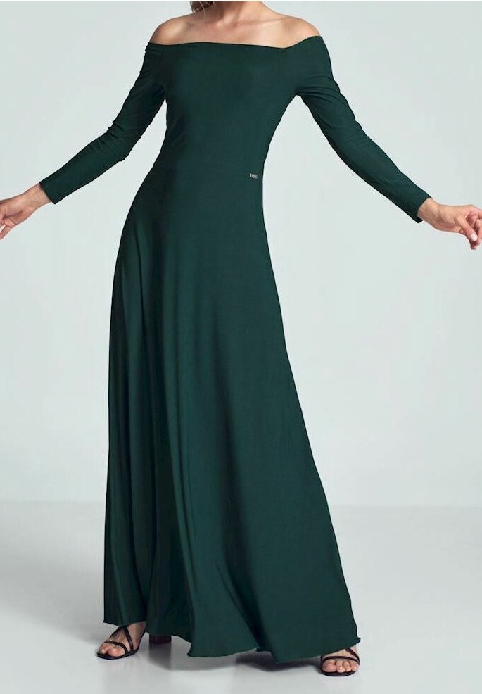 Femme portant une robe longue maxi verte foncée à manches longues et épaules dénudées, debout les bras étendus, portant des sandales noires.