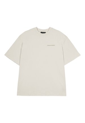Camiseta de algodón color beige claro con un corte relajado, mangas cortas y un pequeño logo "PEGADOR" impreso en un tono similar en el frente.