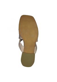Beige sandal with a textured bottom, smooth straps, and a slightly curved heel. The sole has a rubberized surface for grip.