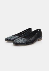 Ballerine nere perforate con suola piatta, bordi scallop e punta rotonda. Presentano una superficie texture e piccoli fori decorativi.